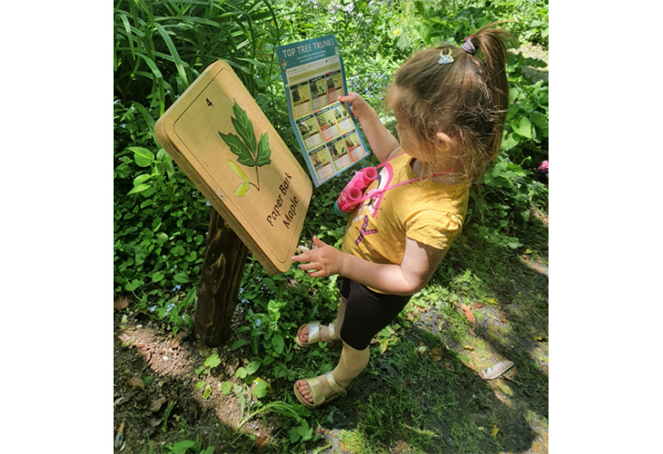 Child using plaque and Tree Trail activity sheet during Creative Waves workshop (Creative waves, June 2021)